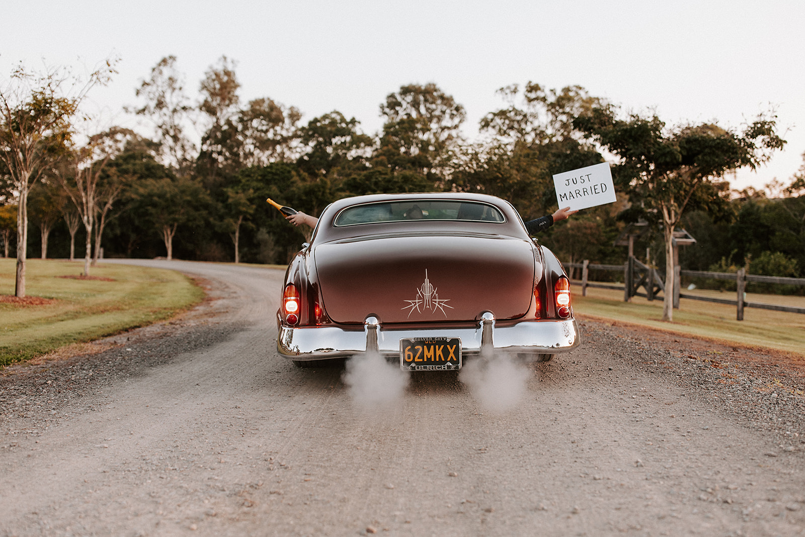 valiant car leaving with just married through gates of yandina station.
